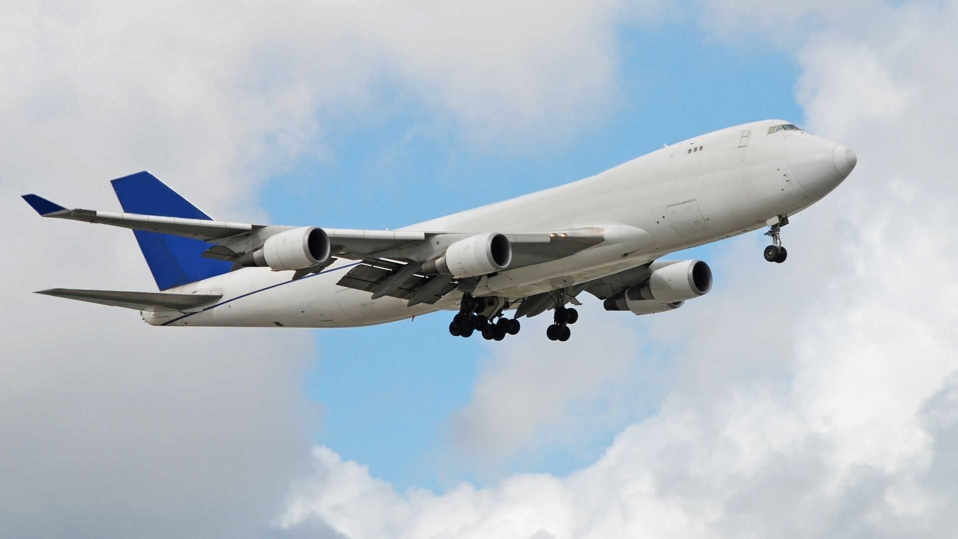 Avión de carga Boeing 777 en vuelo durante una misión global de chárter de carga aérea con tren de aterrizaje extendido.